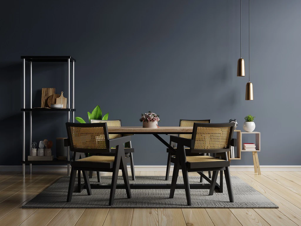 Modern luxury interior design including a dark coloured wall, a metal shelf, a lamp, two wooden chairs and a table on a dark coloured rug.